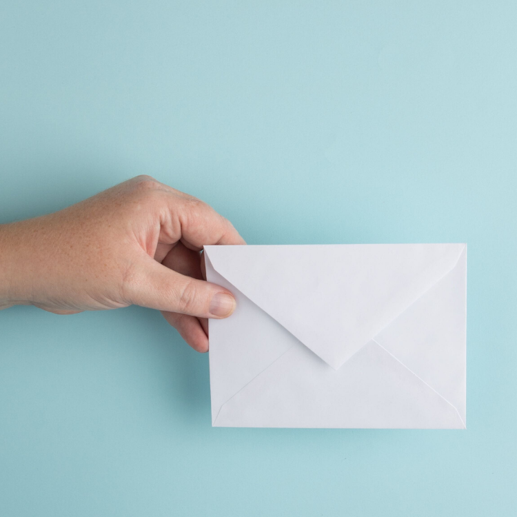 Person showing white envelope - Photo by Erica Steeves on Unsplash